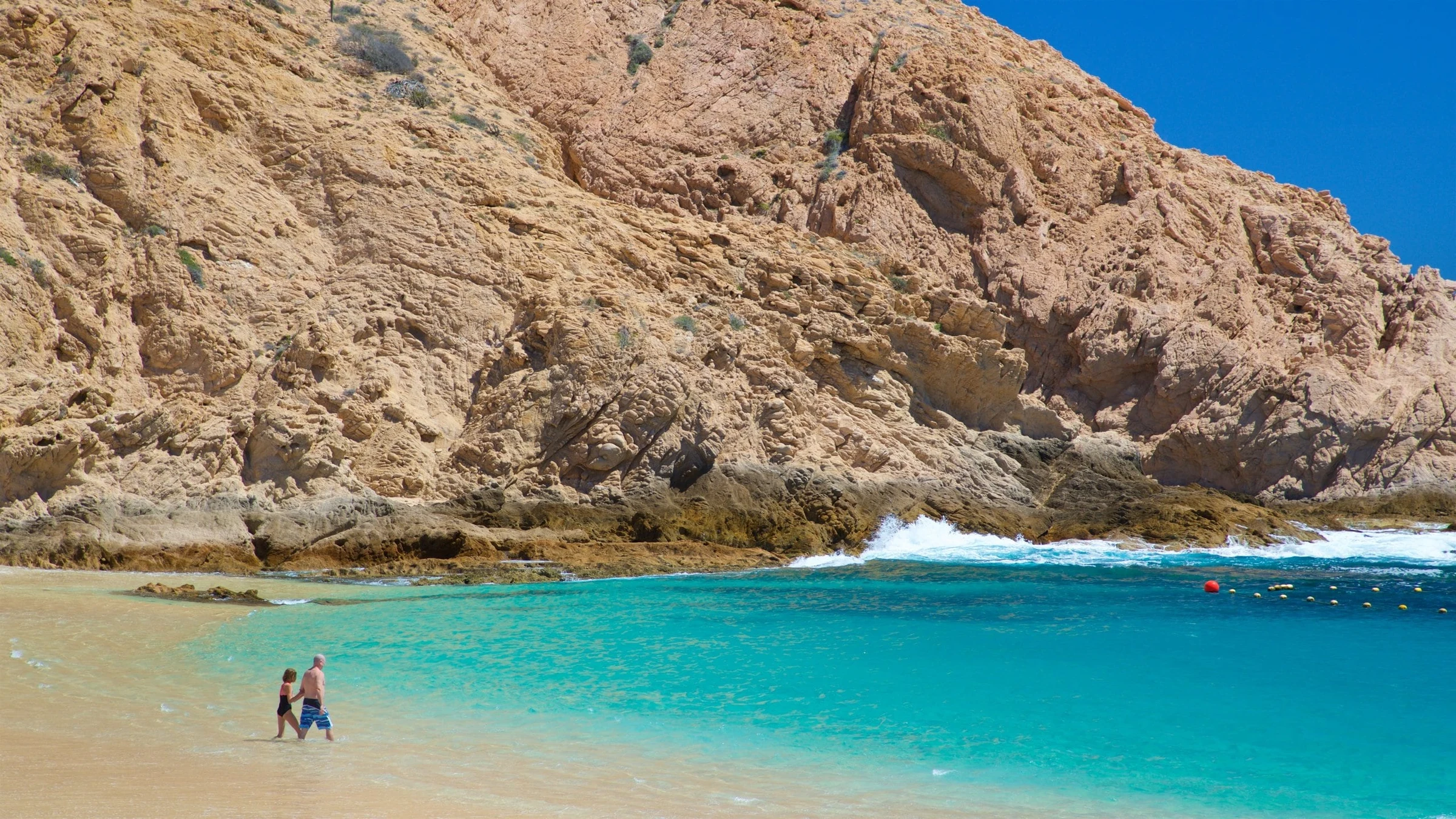 Swimmers in the clear water of Santa Maria Cove