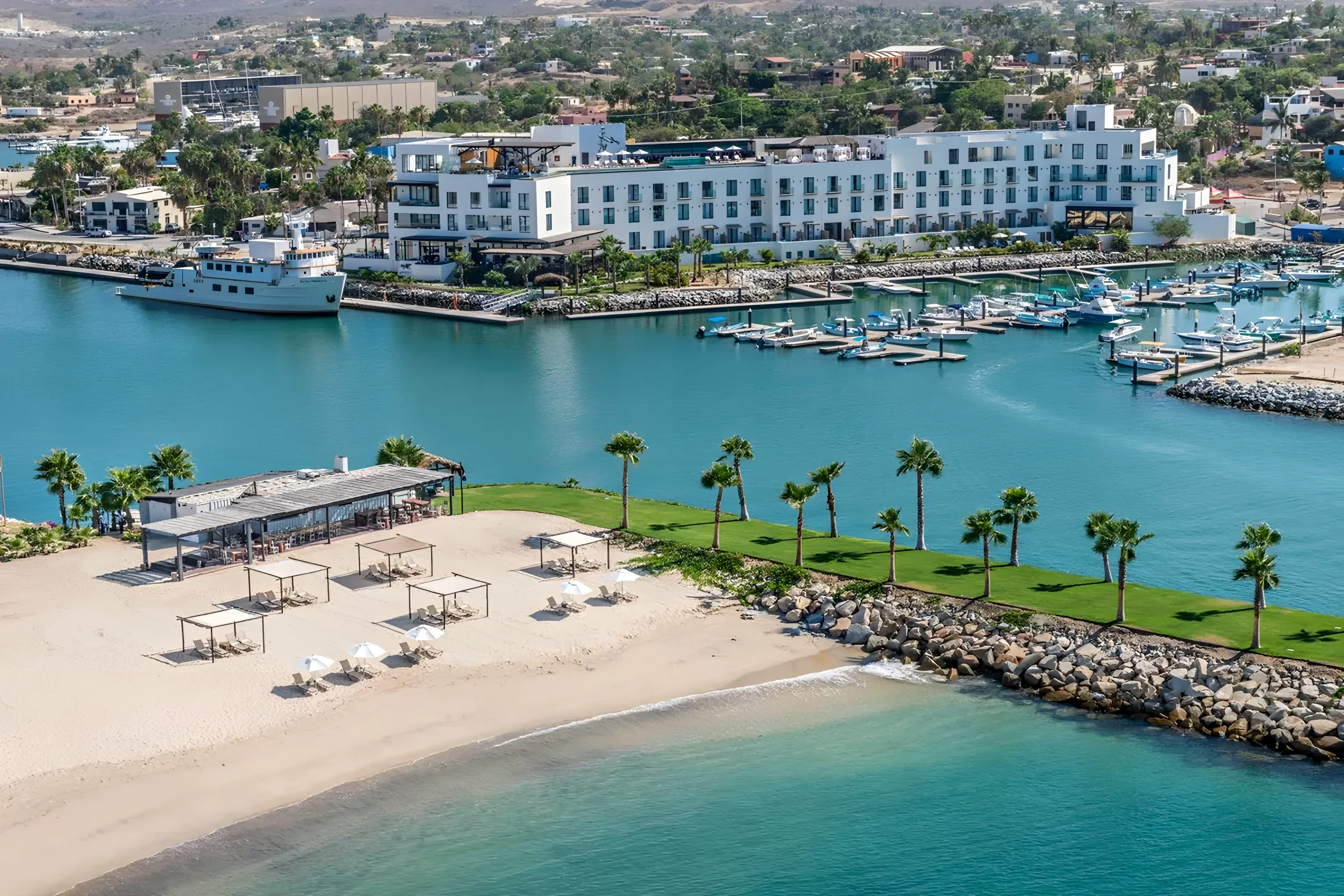 Aerial view of the Puerto Los Cabos marina in San José del Cabo, with white sand and turquoise water beside the boat slips